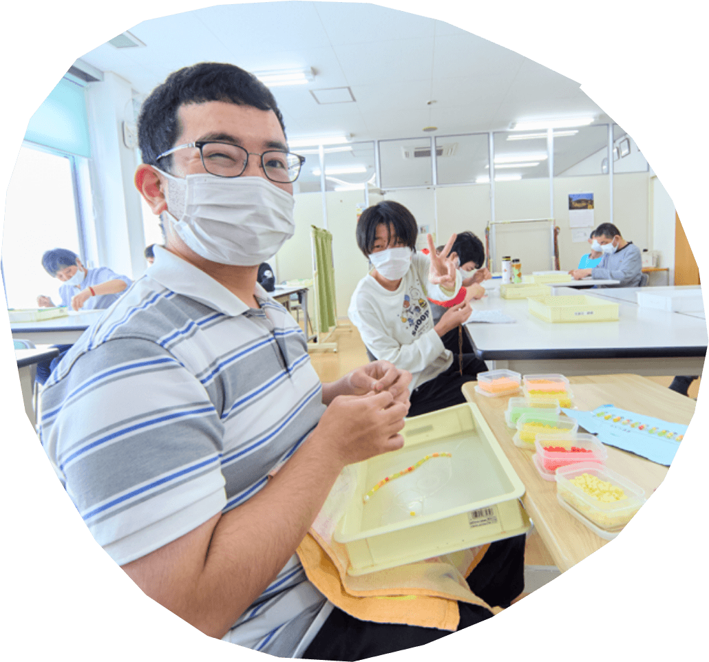 利用者がビーズ細工の作業を楽しんでいる写真