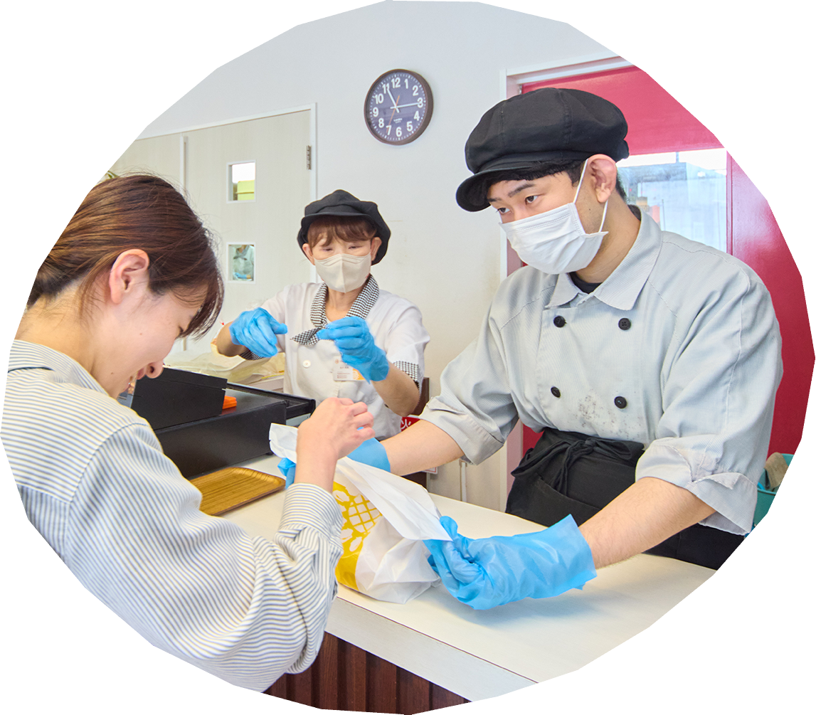 「ひまわりぱん」の厨房でスタッフがパンを確認している写真